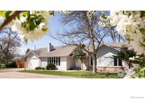 Charming single-story home with a brick and light gray facade, complemented by mature trees and a well-manicured lawn at 1030 55Th St, Boulder, CO 80303