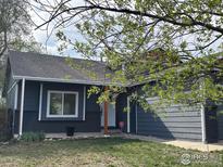 Charming single-story home showcasing gray siding, brick accents, lush lawn, and welcoming front entrance at 1701 Sumner St, Longmont, CO 80501