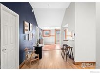 Inviting entryway with stylish decor, a round table, and hardwood flooring, leading to the kitchen at 2351 Federal Blvd # 102, Denver, CO 80236