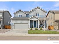 Charming two-story home with a well-manicured front yard and covered porch at 5453 Bauer Dr, Frederick, CO 80504
