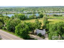 Scenic aerial view of property with river frontage, lush greenery and charming home at 6903 Valmont Rd, Boulder, CO 80301
