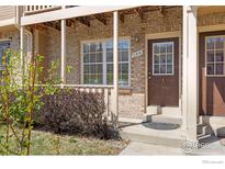 Charming brick townhome featuring a cozy front porch, perfect for relaxing outdoors at 104 Pheasant Run, Louisville, CO 80027