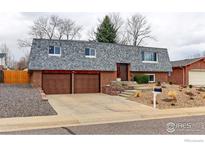 Charming two-story brick home with a gray roof, attached garage, and landscaped front yard at 10679 Union Way, Broomfield, CO 80021