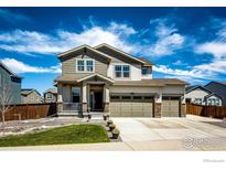 Charming two-story home featuring a three-car garage and a welcoming covered front porch at 1191 Horsetail Loop, Elizabeth, CO 80107