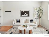 Bright living room featuring modern decor with a white sofa, stylish rug, and decorative accents at 13122 Grant N Cir # B, Thornton, CO 80241