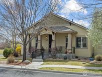 Charming single-story home featuring a welcoming front porch, well-maintained lawn, and attractive landscaping details at 1433 Moonlight Dr, Longmont, CO 80504