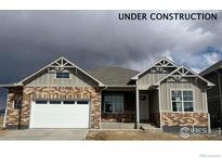 Charming brick and siding home under construction with a two-car garage and inviting entrance at 1884 Sawtooth Mountain Dr, Berthoud, CO 80513