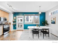 Bright dining area featuring modern table and chairs next to a window with natural light at 2018 Ionosphere St # 8, Longmont, CO 80504