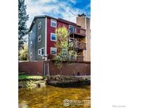 Striking waterfront condo featuring wood balconies overlooking a scenic stream, perfect for serene living at 2879 Shadow Creek Dr # 306, Boulder, CO 80303