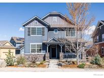 Charming two-story home featuring a cozy front porch, stone accents and landscaped front yard at 2879 Shadow Lake Rd, Lafayette, CO 80026