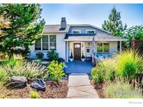 Inviting home showcasing a lush front yard with a stone pathway leading to a covered porch seating area at 2942 4Th St, Boulder, CO 80304