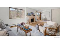 Cozy living room features a decorative fireplace, large windows, and a comfortable seating area at 3335 Chisholm Trl # 206, Boulder, CO 80301