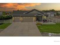 Charming single-Gathering home showcasing a three-car garage, well-manicured lawn, and inviting front porch at 505 Remington Dr, Hudson, CO 80642
