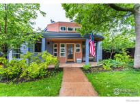 Charming home featuring a covered porch, lush landscaping, and a welcoming front walkway at 516 Valley View Dr, Boulder, CO 80304