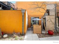 Cozy back patio with outdoor dining, string lights, and vibrant orange facade at 801 Confidence Dr # 2, Longmont, CO 80504