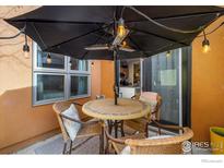 Inviting patio area featuring an umbrella, outdoor lighting, and comfortable seating at 801 Confidence Dr # 2, Longmont, CO 80504