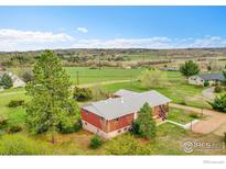 Charming brick home featuring a well-maintained lawn and peaceful country surroundings under a bright blue sky at 832 Fox Hill Ct, Boulder, CO 80303