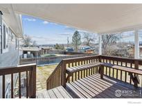 Inviting covered back deck with built-in seating and views of the backyard and beyond at 9525 Damon Dr, Northglenn, CO 80260