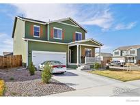 Attractive two-story home featuring an attached two-car garage, well-maintained lawn, and inviting front porch at 1157 Savona Ave, Fort Lupton, CO 80621