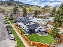 Beautiful exterior view of home with fenced yard, mountain backdrop, and well-manicured landscaping at 1175 Evergreen Ave, Boulder, CO 80304