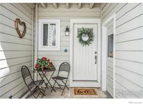Charming front entrance with a decorative wreath, red flowers, and a welcome mat at 1226 Atwood St, Longmont, CO 80501