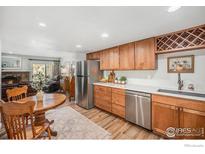 Bright kitchen featuring stainless steel appliances, light wood cabinets, and an adjacent dining area at 1226 Atwood St, Longmont, CO 80501