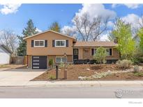 Inviting two-story home with a well-manicured front yard and a modern garage door at 1315 Brookfield Dr, Longmont, CO 80501