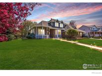 Charming brick home with a lush green lawn and well-manicured landscaping at 2066 Ridgeview Way, Longmont, CO 80504
