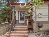 Charming front porch with hanging plants and wooden steps, creating a welcoming entrance at 2069 N Fork Dr, Lafayette, CO 80026