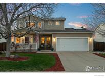 Charming two-story home featuring a well-kept lawn and a two-car garage at 2085 E 127Th Pl, Thornton, CO 80241