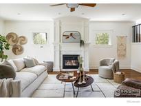 Bright living room features a fireplace, ceiling fan and neutral decor at 3504 Newton St, Denver, CO 80211