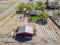 Expansive lot with a house, a red barn, and multiple garden and growing plots at 9951 Sierra Vista Rd, Longmont, CO 80504