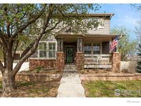 Charming two-story home boasts inviting porch and well-manicured front yard at 14215 Waterside Ln, Broomfield, CO 80023