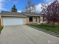 Charming one-story home with a brick facade, an attached garage, and a well-manicured lawn at 1504 Washington Ave, Louisville, CO 80027