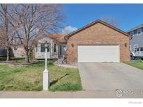 Charming one-story brick home with a well-maintained lawn and attached two-car garage at 2131 Kay St, Longmont, CO 80501