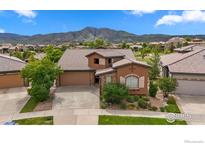 Beautiful two-story home with a tile roof, complemented by landscaped front yard and stunning mountain views at 2353 S Juniper Way, Lakewood, CO 80228