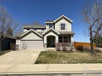 Charming two-story home featuring a covered front porch and a well-maintained lawn at 2432 Tyrrhenian Dr, Longmont, CO 80504