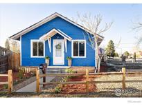 Charming blue home with a manicured front yard, white trim, and a welcoming front porch at 245 2Nd St, Fort Lupton, CO 80621