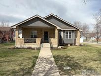 Charming single-Gathering home with a manicured lawn, covered front porch, and a well-maintained exterior at 318 E Iowa Ave, Berthoud, CO 80513