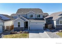 Charming two-story home with a well-manicured lawn, attached garage, and beautiful architectural details at 3196 Park St, Mead, CO 80542