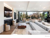 Expansive living room featuring fireplace, large sectional, and sliding glass doors to outdoor seating area at 3633 21St St, Boulder, CO 80304