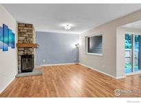 Bright living room features hardwood floors and a stone fireplace at 6221 Willow Ln, Boulder, CO 80301