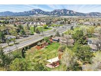 Stunning aerial view of property with lush yard, patio area, and beautiful mountain backdrop at 700 Brooklawn Dr, Boulder, CO 80303