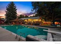 Stunning backyard featuring a large in-ground pool, a gazebo, and ample space for outdoor entertaining at dusk at 7451 Rozena Dr, Longmont, CO 80503