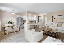 Bright living room and dining area featuring white furniture and stainless steel appliances at 1350 Josephine St # 502, Denver, CO 80206