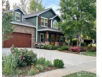 Charming home featuring an attached garage, beautiful landscaping and a welcoming front porch with stone accents at 1715 Wales Dr, Berthoud, CO 80513