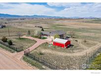 Expansive property featuring a ranch-style home, detached garage, long driveway, and stunning mountain views at 1916 W County Road 6, Berthoud, CO 80513