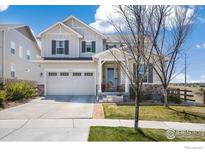 Charming two-story home featuring stone accents, a two-car garage, a covered front porch and nicely-manicured landscaping at 24222 E Canyon Pl, Aurora, CO 80016