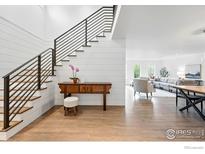 Bright entryway featuring modern staircase, wood floors, shiplap accent wall, and a glimpse into the living room at 2970 21St St, Boulder, CO 80304