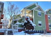 Attractive multi-level home with a green exterior, brick accents, covered balconies, and snowy landscaping at 3025 Broadway St # 17, Boulder, CO 80304